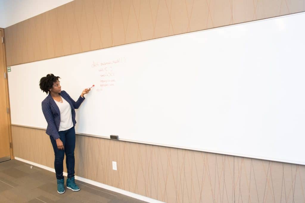 A woman teaching a lesson with a whiteboard.